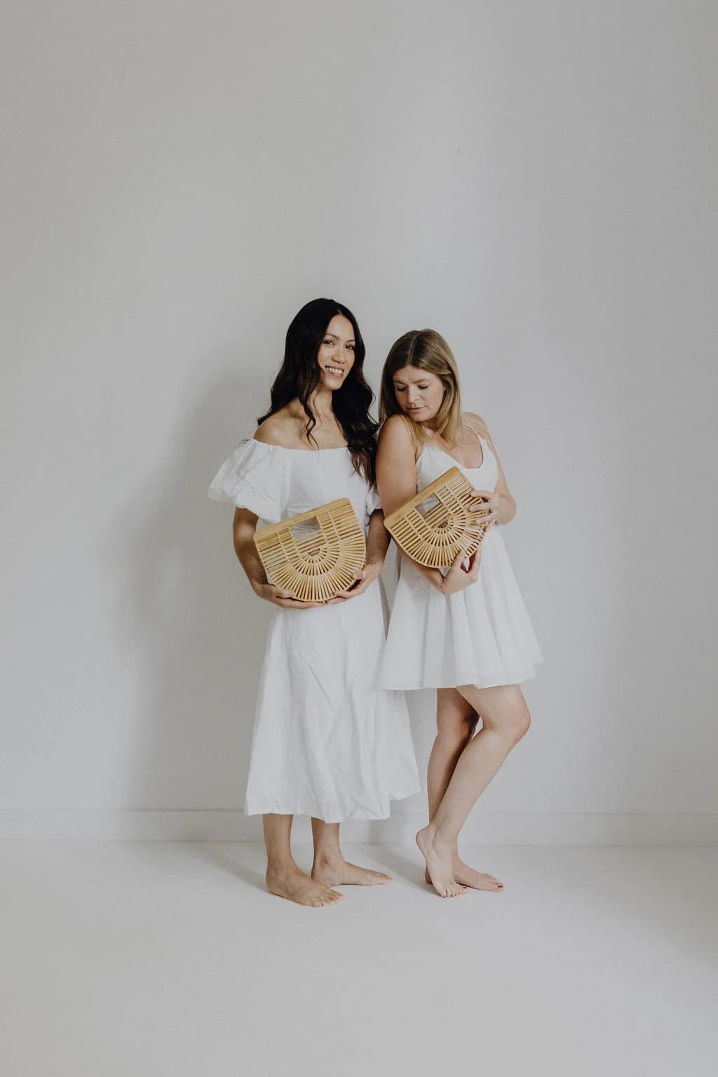 Zwei Frauen mit BUMI Bambus-Taschen im Sommerlook